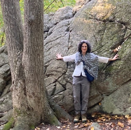 Carole Greenfield's inspiration for her first poetry book Weathering Agents was a geology textbook. Here she poses leaning against the face of a large rock.